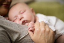 Selective focus of baby sleeping on mother in living room at home — Stock Photo