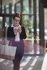 Бізнес-леді з сумкою за допомогою мобільного телефону за межами офісної будівлі — стокове фото
