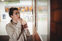Jovem mulher olhando para bordo na estação ferroviária — Fotografia de Stock
