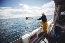Pescador lanzando boya al mar - foto de stock