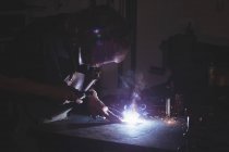Blacksmith welding a metal in workshop — Stock Photo