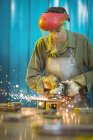 Female welder using circular saw in workshop — Stock Photo