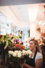 Жіночий флорист організовує квіти в квітковому магазині — стокове фото