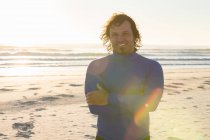 Surfista sorridente alla telecamera sulla spiaggia — Foto stock