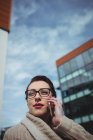 Young woman talking on phone against sky — Stock Photo