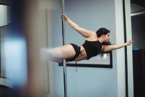 Ballerina polacca che pratica la pole dance in palestra — Foto stock