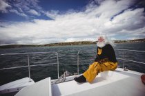 Pescatore premuroso seduto sulla barca da pesca — Foto stock