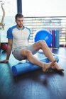 Man performing exercise using foam roll in clinic — Stock Photo