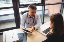 Arzt diskutiert mit Patient über digitales Tablet im Krankenhaus — Stockfoto