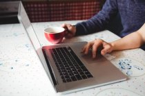 Abgeschnittenes Bild eines Paares mit Laptop beim Kaffee zu Hause — Stockfoto
