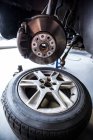 Primer plano de la rueda de rotura y piezas de repuesto en el garaje de reparación - foto de stock