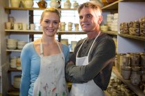 Portrait of happy potters standing in pottery workshop — Stock Photo
