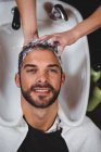 Mann lässt sich im Salon die Haare waschen — Stockfoto