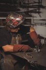 Forgeron travaillant sur une pièce métallique en atelier — Photo de stock