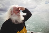 Pescatore in piedi sulla barca da pesca e guardando lontano — Foto stock
