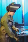 Female welder using clamp tool in workshop — Stock Photo