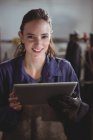 Retrato de soldador fêmea segurando tablet digital na oficina — Fotografia de Stock