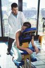 Fisioterapista che massaggia la schiena alle pazienti in clinica — Foto stock