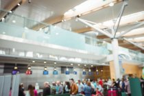 Blurred view of passengers waiting in queue at a check-in counter in airport terminal — Stock Photo