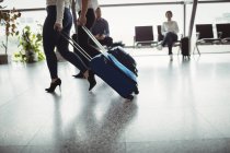 Business people walking with luggage in airport terminal — Stock Photo
