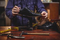 Средняя часть сапожника-мужчины ремонтирует обувь в мастерской — стоковое фото