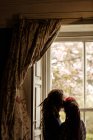 Romantic couple standing by window at home — Stock Photo