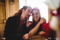 Hipster couple listening to music through mobile phone at home — Stock Photo
