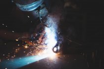 Blacksmith welding a piece of metal in workshop — Stock Photo