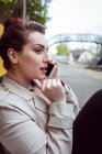 Красива жінка розмовляє на мобільному телефоні на платформі залізничної станції — стокове фото
