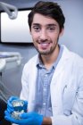 Портрет стоматолога с моделью рта в клинике — стоковое фото