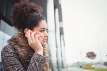 Smart woman talking on phone outside building — Stock Photo