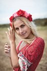 Портрет Безтурботної блондинки в квітковій тіарі, що стоїть на полі — стокове фото