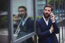Бізнесмен розмовляє на мобільному телефоні поза офісом — стокове фото