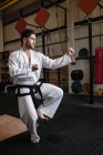 Hombre practicando karate en gimnasio - foto de stock