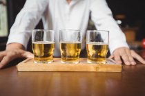 Primer plano de vasos de cerveza en el mostrador del bar en el bar - foto de stock