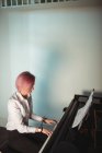 Женщина играет на пианино в музыкальной студии — стоковое фото