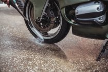 Lavaggio moto con rondella a pressione in officina — Foto stock