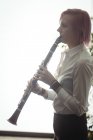 Bella donna che suona un clarinetto nella scuola di musica — Foto stock