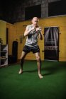 Beau boxeur thaïlandais pratiquant la boxe dans le gymnase — Photo de stock