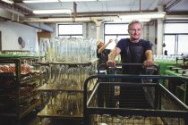 Souffleur de verre senior poussant un chariot à l'usine de soufflage de verre — Photo de stock