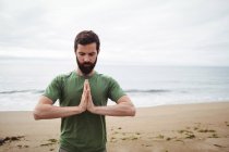 Man performing yoga on beach — Stock Photo
