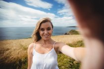Camera point of view of smiling woman standing in field — Stock Photo