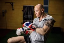 Schöner tätowierter thailändischer Boxer beim Boxen im Fitnessstudio — Stockfoto