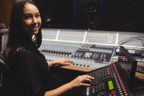 Estudante feminina usando teclado mixer som em um estúdio — Fotografia de Stock