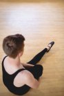 Aus der Vogelperspektive: Ballerino dehnt sich auf Holzboden im Ballettstudio — Stockfoto