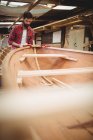 Homme préparant le cadre de bateau en bois dans le chantier naval — Photo de stock