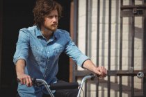 Schöner Mann mit Fahrrad an einem sonnigen Tag — Stockfoto