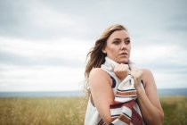 Женщина, стоящая в поле в ветреную погоду — стоковое фото