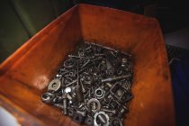 Varias tuercas en contenedor en taller mecánico industrial - foto de stock