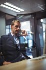 Бизнесмен разговаривает по телефону за столом в офисе — стоковое фото